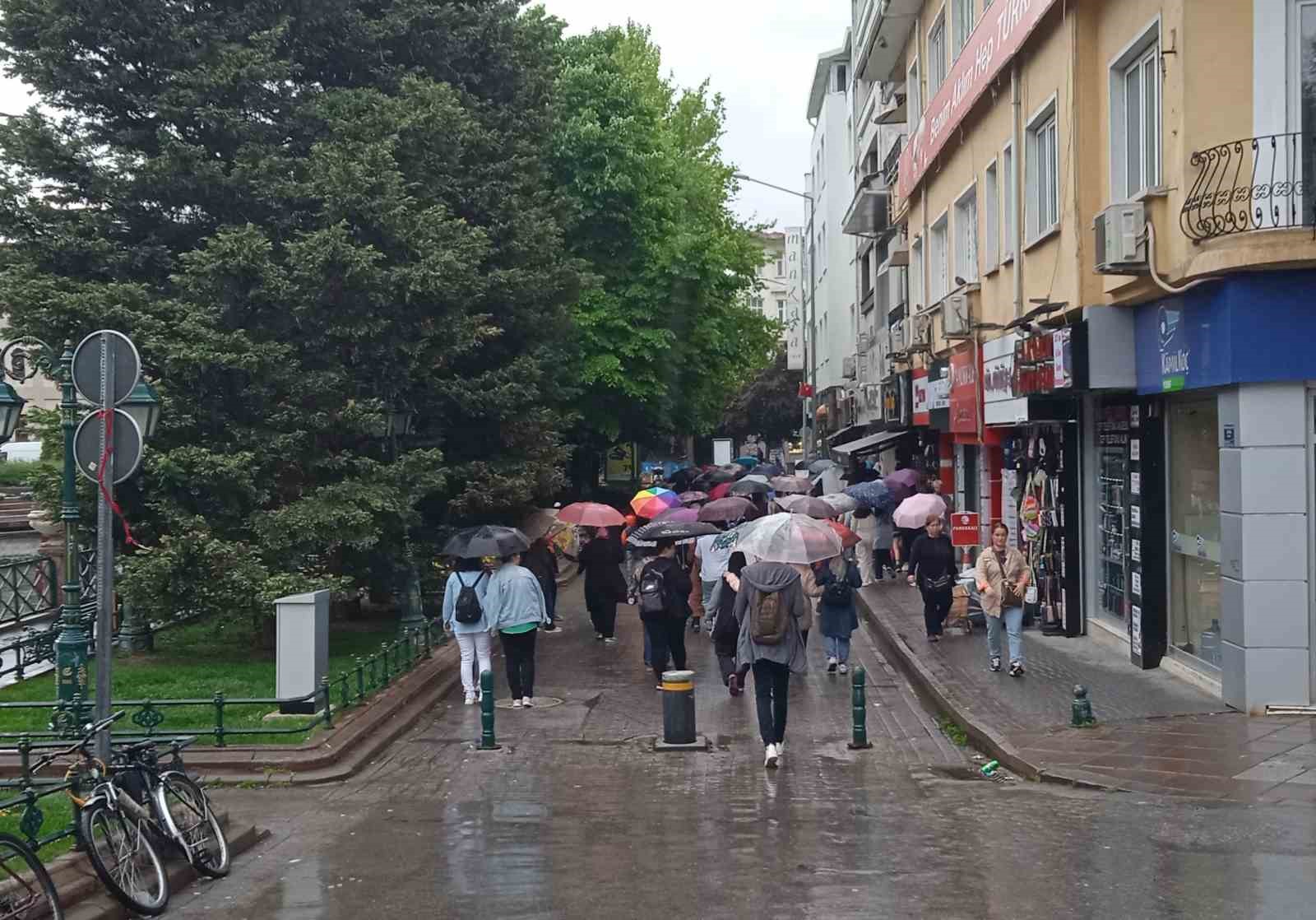 ESKİŞEHİR'DE BİR GRUP VATANDAŞ, ÖĞLE SAATLERİNDE BAŞLAYAN YAĞMURDAN KORUNMAK İÇİN