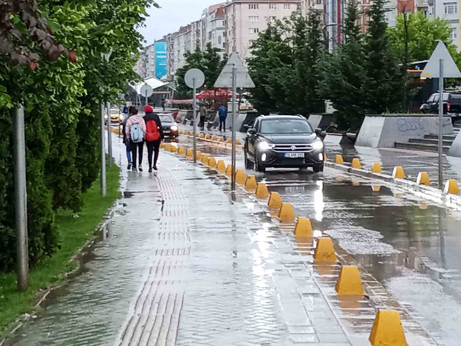 HATBOYU'NDAN GEÇEN VATANDAŞLAR VE SU BİRİKİNTİSİNİN ÜSTÜNDEN GEÇEN BİR ARAÇ