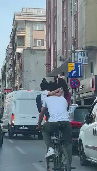 SULTANGAZİ'DE KUCAĞINA ALDIĞI İKİ ÇOCUĞU İLE BİRLİKTE BİSİKLETE BİNEREK YOLCULUK