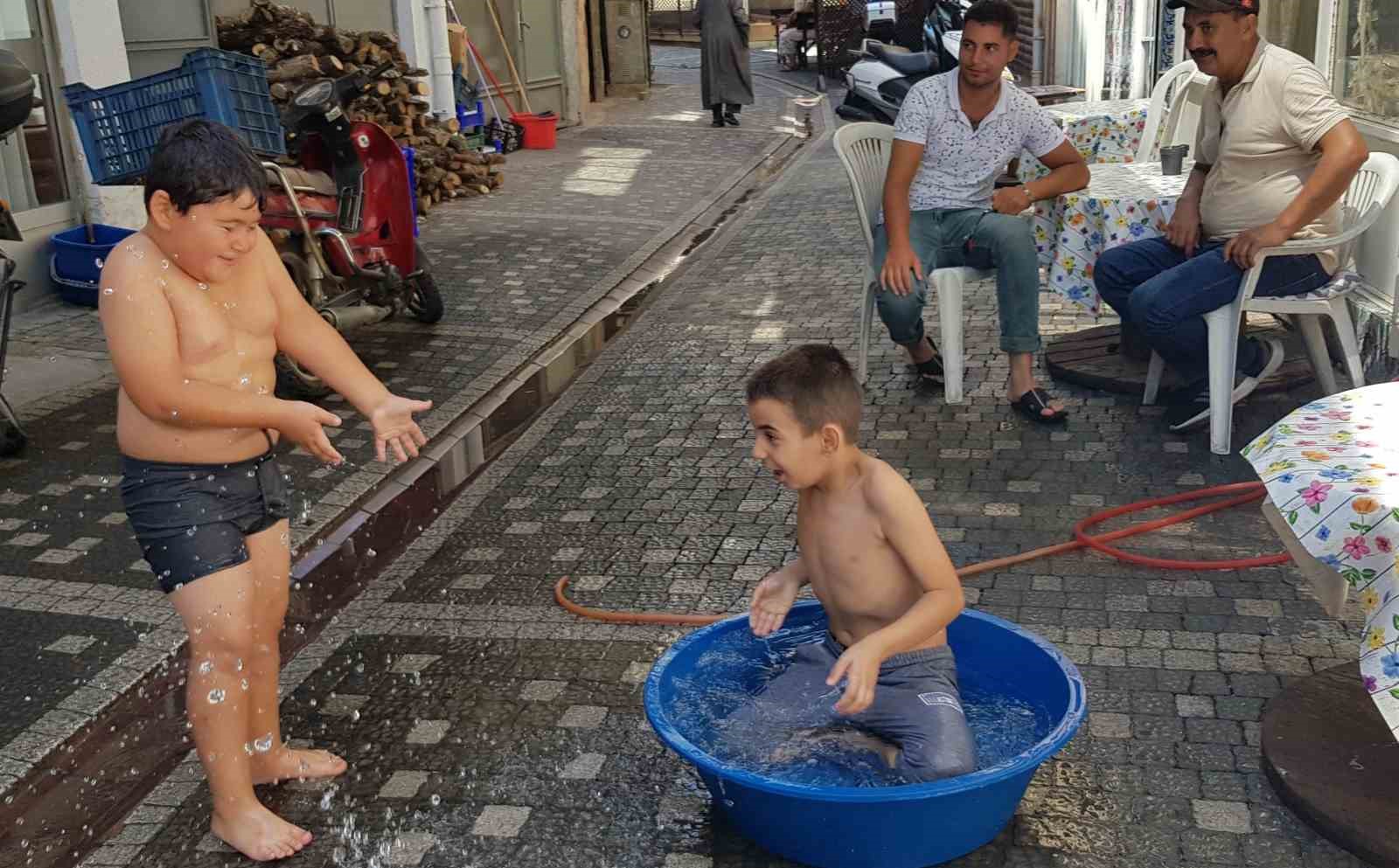 ESNAF, ÇOCUKLARININ SERİNLEMESİ İÇİN ÇAREYİ SOKAĞA LEĞEN KOYMAKTA BULDU. ÇOCUKLARIN