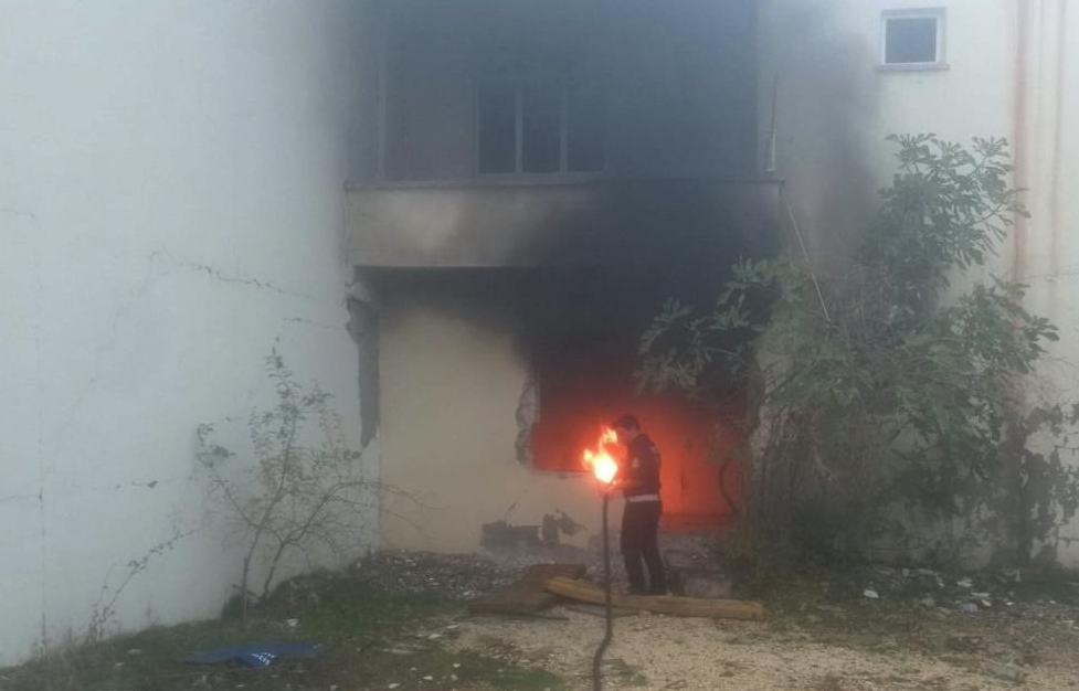 Adıyaman’da, ağır hasarlı bir bina içerisinde yakılan araç lastiği korkuya
