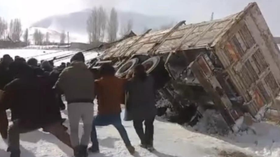 Van’ın Gürpınar ilçesinde yan yatan saman yüklü kamyon, vatandaşlar tarafından