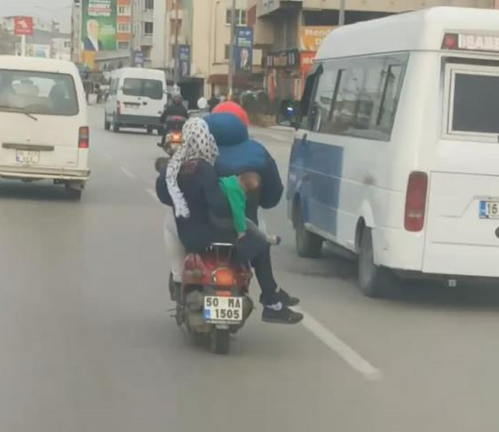Bursa’da bir aile, motosiklete çocuklarıyla beraber binerek ilerledi. Tehlikeli yolculuk