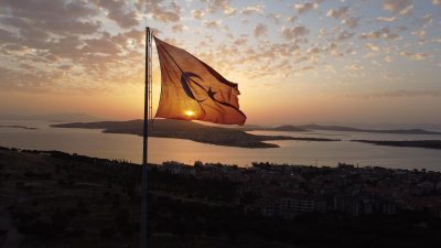 Cennet Tepesi’nde bulunan dev Türk bayrağı, gün batımında Ayvalık Adaları