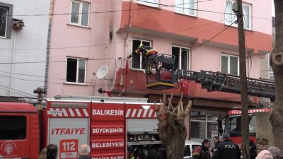 Balıkesir’de yangın söndürme çalışmaları sırasında binanın dış cephesinde asılı bulunan
