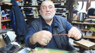 Burhaniye’de, 71 yaşındaki Cevat Büke tespih dizerek para kazanıyor. Yüzlerce