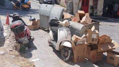Bazı çöp konteynerlerdeki çöpler arasına ve kaldırım üstüne bırakılanmotosikletler merak
